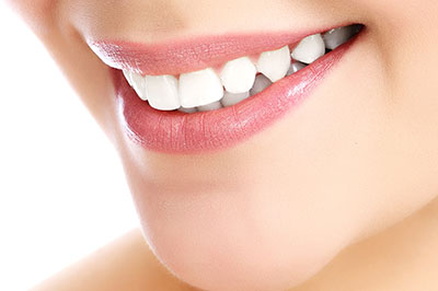 The image shows a close-up of a person s face with a focus on their teeth, which appear to be clean and well-maintained, and their lips, which are slightly parted revealing a smile.