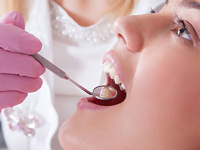 A dental professional performing oral care on a patient in a clinical setting.