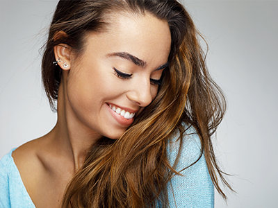 A woman with long hair smiles at the camera.